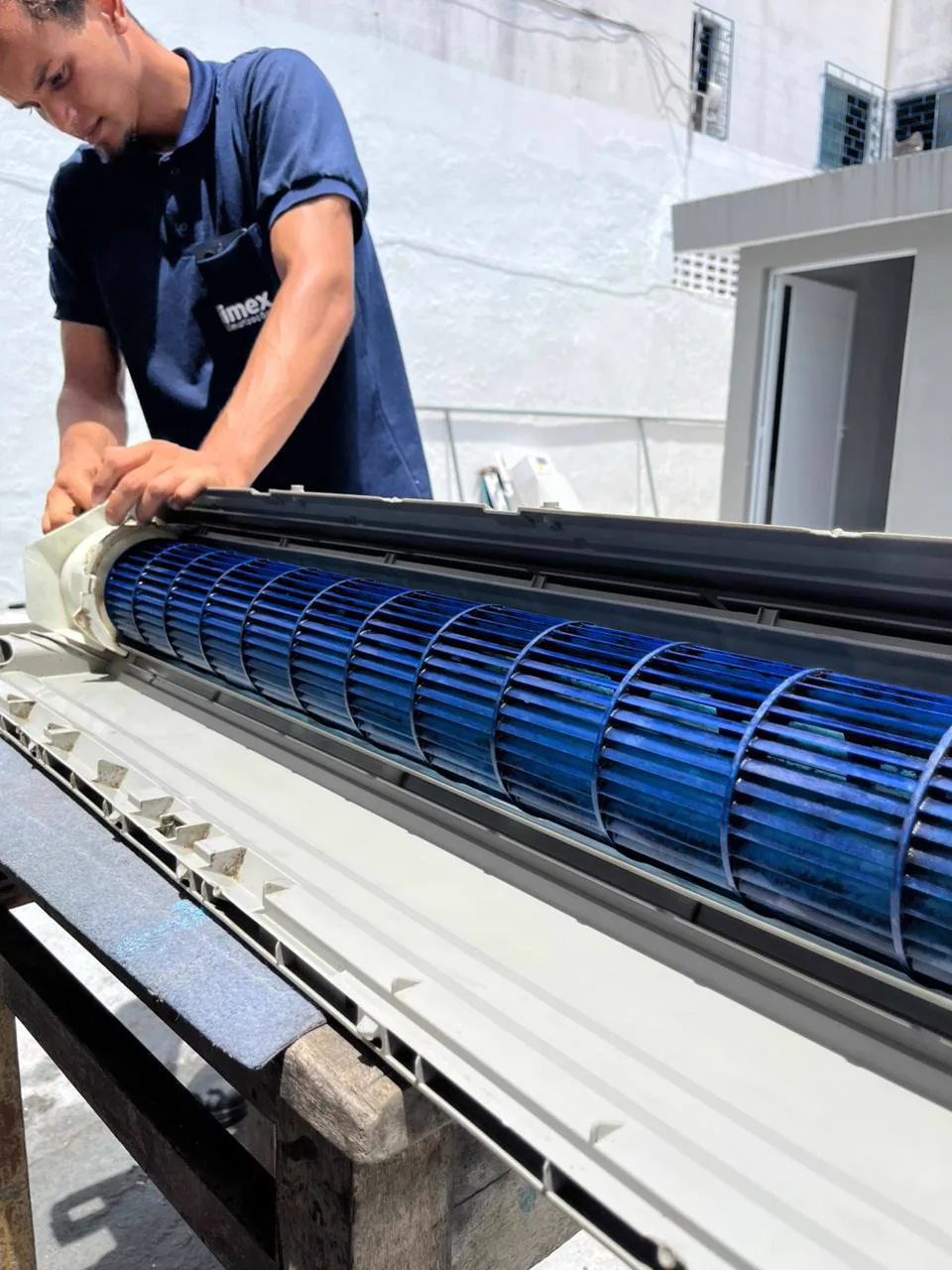 Técnico da Climex realizando limpeza completa de ar-condicionado